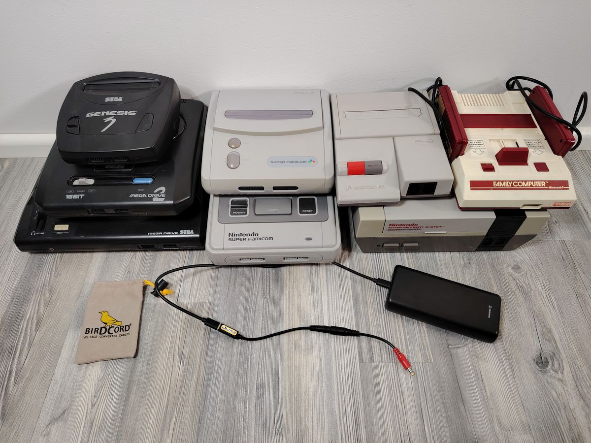 various retro game consoles with a portable birdcord voltage converter plus power bank in front sega mega drive 2 3 nintendo nes snes